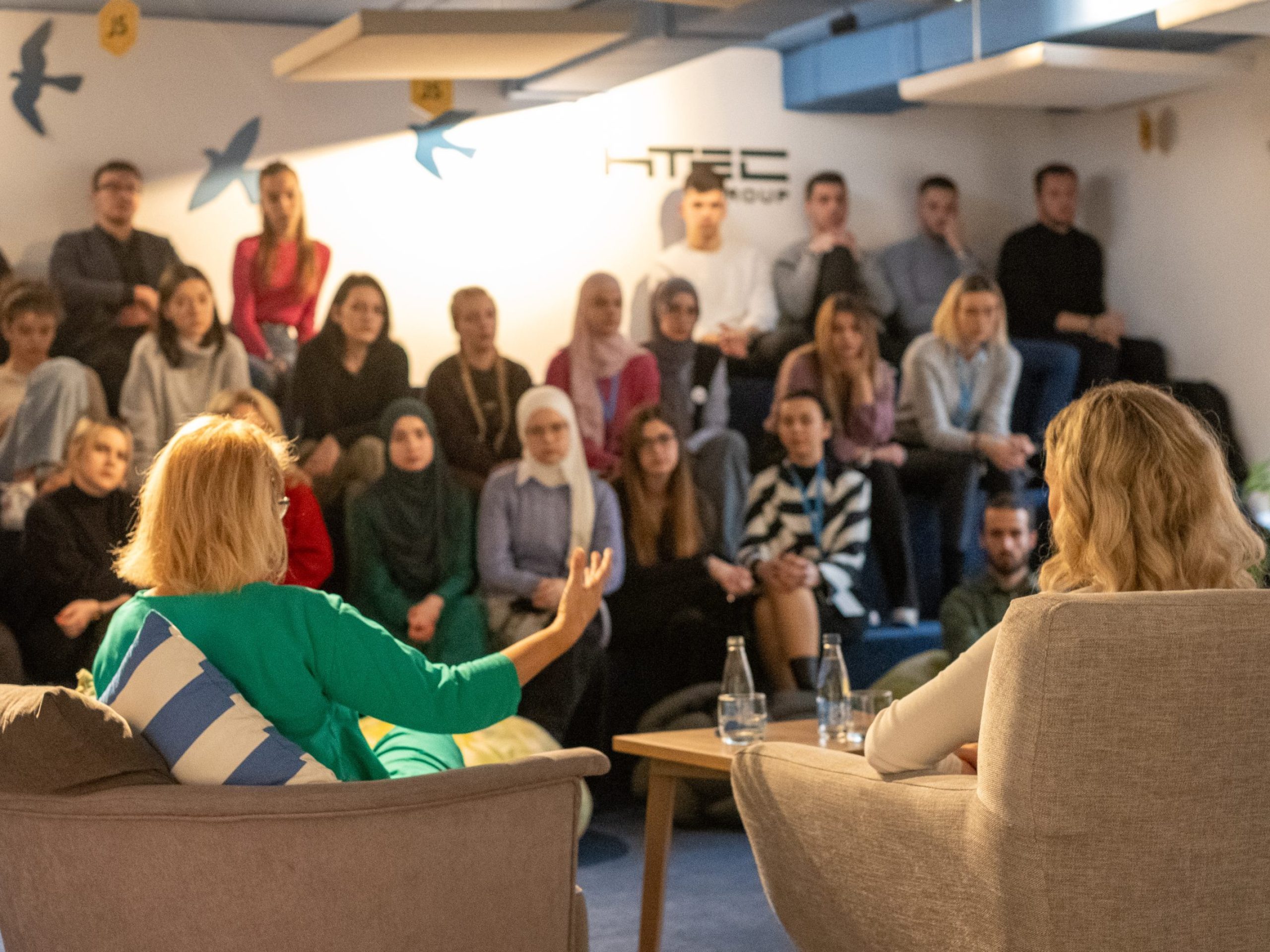 Crowd of students listening to an interview between two women professionals